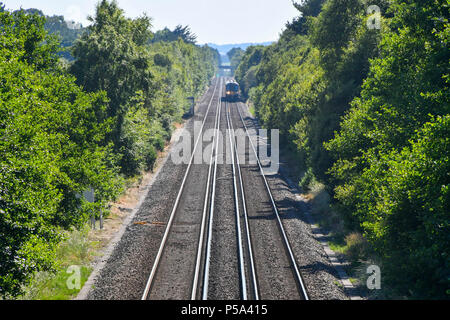 Holton Heath Station, Dorset, UK.  26th June 2018. UK Weather.   A London bound train at Holton Heath with delays on South Western Railways in Dorset after a small fire under a train between Surbiton and Weybridge blocked the West bound line.  This incident is on top of the speed restrictions on the railways due to the risk of the lines buckling due to the hot temperatures from the current heatwave.  Picture Credit: Graham Hunt/Alamy Live News Stock Photo