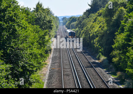 Holton Heath Station, Dorset, UK.  26th June 2018. UK Weather.   A London bound train at Holton Heath with delays on South Western Railways in Dorset after a small fire under a train between Surbiton and Weybridge blocked the West bound line.  This incident is on top of the speed restrictions on the railways due to the risk of the lines buckling due to the hot temperatures from the current heatwave.  Picture Credit: Graham Hunt/Alamy Live News Stock Photo