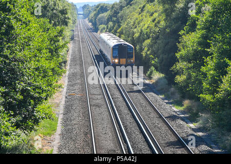 Holton Heath Station, Dorset, UK.  26th June 2018. UK Weather.   A London bound train at Holton Heath with delays on South Western Railways in Dorset after a small fire under a train between Surbiton and Weybridge blocked the West bound line.  This incident is on top of the speed restrictions on the railways due to the risk of the lines buckling due to the hot temperatures from the current heatwave.  Picture Credit: Graham Hunt/Alamy Live News Stock Photo