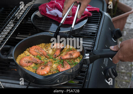 Close up of Paella being cooked on a barbecue in the summer heatwave in the UK. Stock Photo