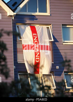 Sheerness, UK. 26th June, 2018. FIFA World Cup: a large St. George's /  England flag flown from a window at sunset to celebrate the World Cup. Credit: James Bell/Alamy Live News Stock Photo