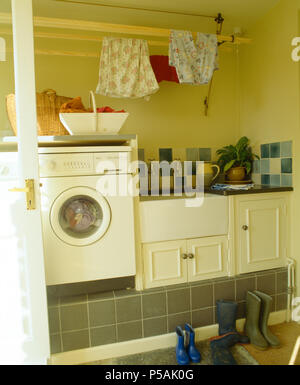 Laundry room interior. Utility room with washing machine, cleaning  equipment, home cleaners, clean wipes, hanging colorful shirts on  clothesline on wh Stock Photo - Alamy