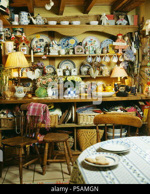 Collection of pottery cups and plates on antique pine dresser in cottage kitchen Stock Photo