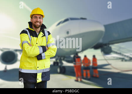 portrait of smiling workers from ground crew at the airport - handling and security control of an aircraft Stock Photo