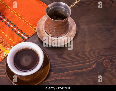 Coffee. Turkish coffee being made in a traditional way. Armenian Turkish coffee. The copper coffee pot and cup of coffee on the table. Traditional ser Stock Photo