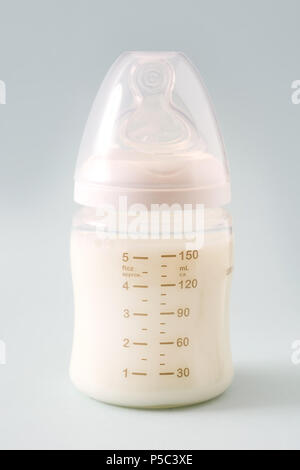 Baby bottle and milk on gray background Stock Photo