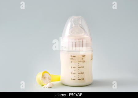 Baby bottle and milk on gray background Stock Photo