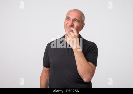Middle aged man with hand looking up thinking Stock Photo