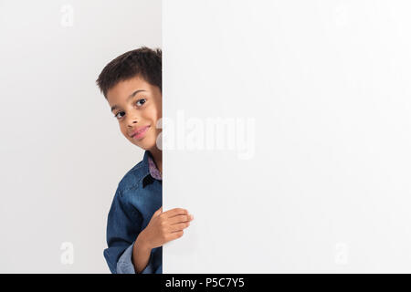 Portrait of a happy little boy holding a blank board against white background. Stock Photo