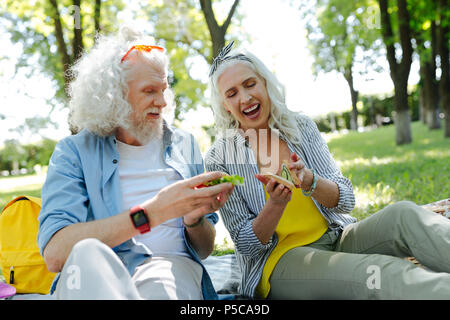 Delighted nice couple having sandwiches Stock Photo