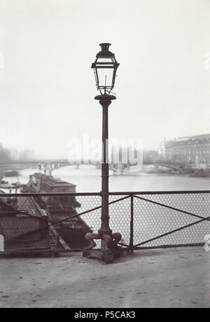 Pont des Arts. no.37. English: Lamp with iron post mounted on claw foot, in front of wire parapet of bridge. River with another bridge in background. 1878. N/A 327 Charles Marville, Pont des Arts, 1878 Stock Photo