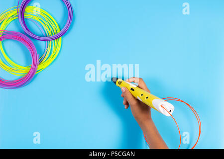 Child draws with 3d pen. Kid holding 3d pen with plastic filament Stock Photo