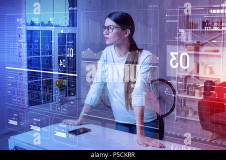 Attentive woman putting her hands on the table and looking at the screen Stock Photo