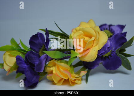 Women's interesting hair decoration, festive look. Beautiful head hoop made of blue, yellow flowers and green leaves placed on white background. Stock Photo