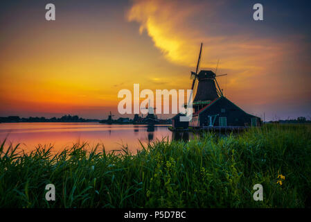 Sunset above farm houses and windmills of Zaanse Schans in the Netherlands Stock Photo