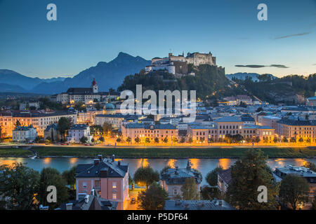 Aerial panoramic view of the historic city of Salzburg with famous Hohensalzburg Fortress in mystic evening twilight during blue hour at dusk in sprin Stock Photo
