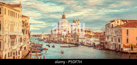 Classic panoramic view of famous Canal Grande with scenic Basilica di Santa Maria della Salute in beautiful golden evening light at sunset with retro 