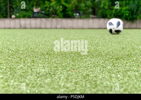 Football lawn, ball in background. Soccer closeup detail wallpaper texture. Stock Photo