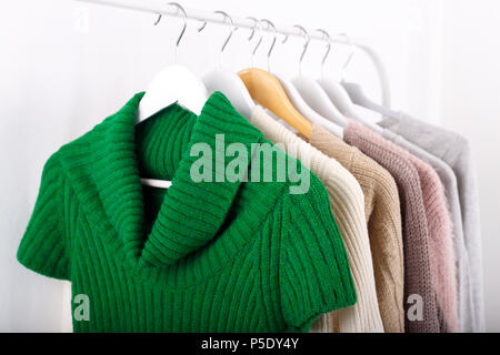 Warm knitted, autumn, winter clothes hanging on a rack, trending concept Stock Photo