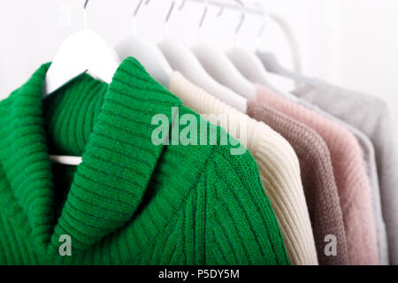 Warm knitted, autumn, winter clothes hanging on a rack, trending concept Stock Photo