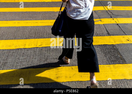 Walking woman crossing road at Causeway Bay city shopping district Hong Kong Stock Photo