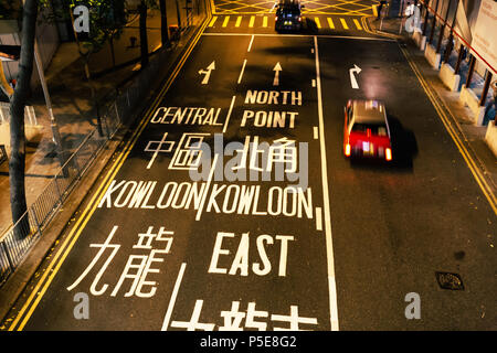 HONG KONG - JUNE 01, 2018: Red taxi driving on road in Hong Kong at night Stock Photo