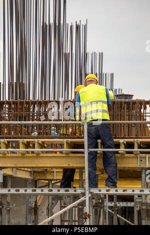 Workers installing metal rebar and rods for concrete pouring. Developer concept. Selective focus. Stock Photo