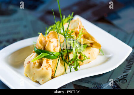 pancakes with meat decorated green onions Stock Photo