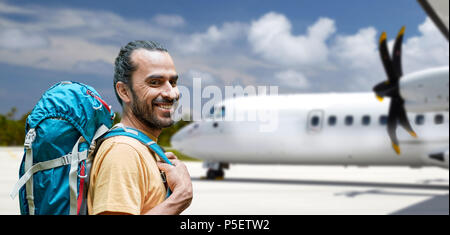 tourist man with backpack traveling by plane Stock Photo