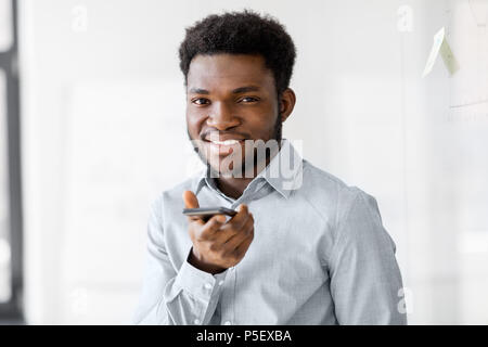 businessman records voice by smartphone at office Stock Photo