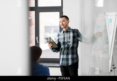 man showing tablet pc to creative team at office Stock Photo