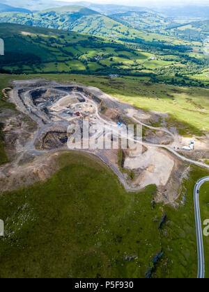 Aerial drone view of an old quarry scarring the otherwise green landscape in the Brecon Beacons national park