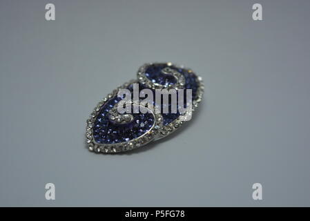 Jewelry, women's original pendant made of purple and white stones arranged on white background. Stock Photo