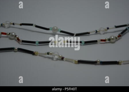 Jewelry, women's necklace made of black and white beads are arranged on a white background. Stock Photo