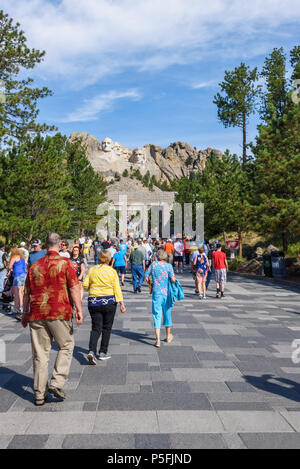 MOUNT RUSHMORE, KEYSTONE, SOUTH DAKOTA, USA - JULY 20, 2017: Visitors walk along the Avenue of Flags with Mount Rushmore in the background Stock Photo