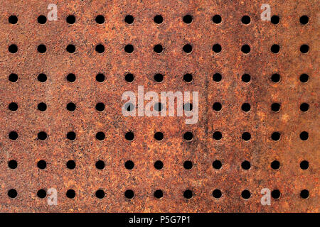 Rusty Texture of Perforated Metal with Regular Pattern of Holes. Stock Photo