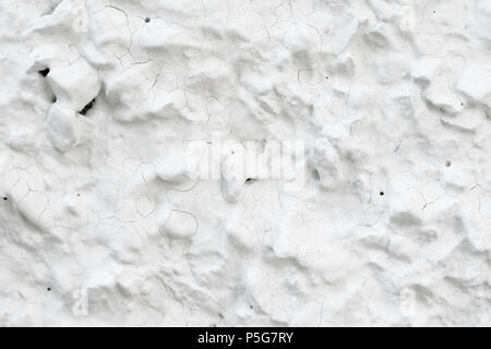 Rough Concrete Wall Decoration, Painted White. White Concrete Wall with Many Protruding Stones. Stock Photo