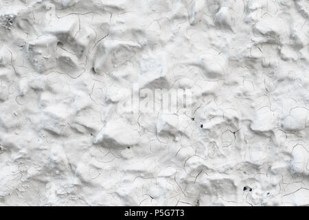 Rough Concrete Wall Decoration, Painted White. White Concrete Wall with Many Protruding Stones. Stock Photo