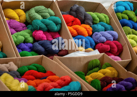 Different color yarns in boxes on the store shelf. Stock Photo