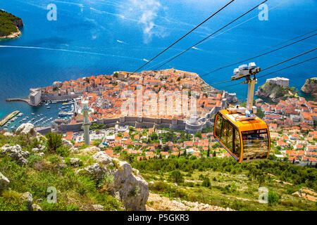 Aerial panoramic view of the old town of Dubrovnik with famous Cable Car on Srd mountain on a sunny day with blue sky and clouds in summer, Croatia