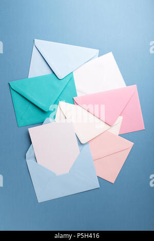 Group of colorful envelopes on grey table with empty card. Correspondence concept. Mockup. Stock Photo