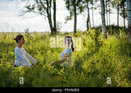 Portrait of two young woman enjoying pranayama or breathing exercises, relaxing, feeling alive and dreaming Stock Photo