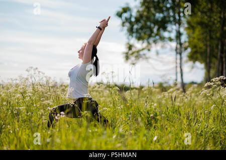 Young woman practicing yoga outdoor in park. Stock Photo