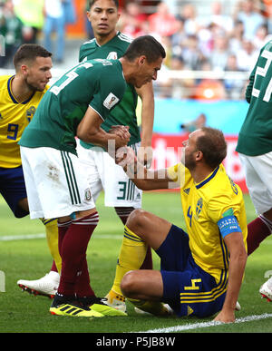 Yekaterinburg, Russia. 27th June, 2018. Hector Moreno (L front) of Mexico pulls up Andreas Granqvist of Sweden during the 2018 FIFA World Cup Group F match between Mexico and Sweden in Yekaterinburg, Russia, June 27, 2018. Credit: Li Ming/Xinhua/Alamy Live News Stock Photo