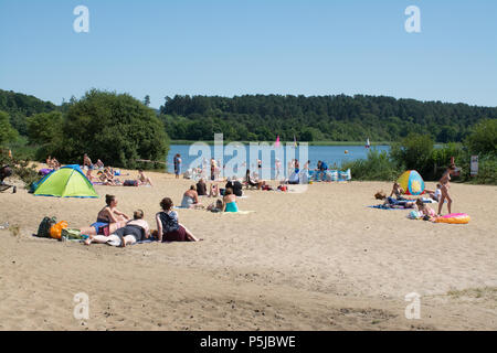 Frensham Pond, Surrey, UK. 27th June, 2018. The unbroken sunshine continues. Lots of sun-worshippers were enjoying themselves on the sand by Frensham Great Pond today, probably the closest thing to a beach in Surrey. Stock Photo