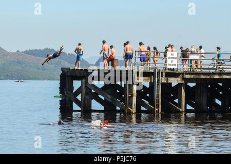 Luss, Loch Lomond, Scotland, UK - 27 June 2018: uk weather - too hot not to.  Crowds flock to Luss to enjoy the beach and water sports as the temperature continues to rise Credit: Kay Roxby/Alamy Live News Stock Photo