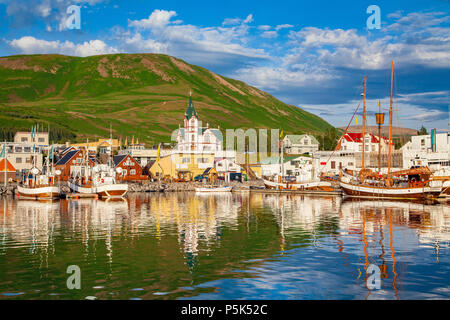 Scenic view of the historic town of Husavik in beautiful golden evening light at sunset with blue sky and clouds, north coast of Iceland Stock Photo