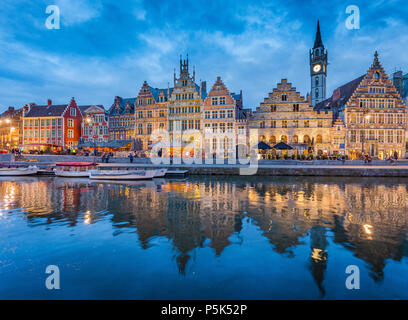Famous Graslei in the historic city center of Ghent illuminated in beautiful post sunset twilight during blue hour at dusk with Leie river, Belgium Stock Photo