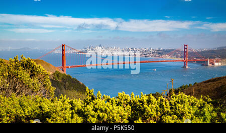Classic aerial view of famous Golden Gate Bridge with the skyline of San Francisco in the background on a beautiful sunny day with blue sky and clouds Stock Photo