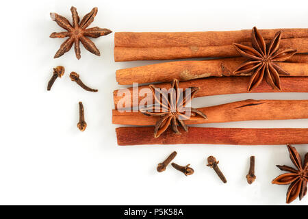 Whole spices of cinnamon, star anise and cloves on white background in flat lay Stock Photo